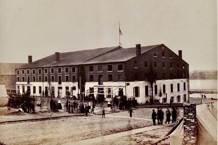 An old photo of a building with people outside.