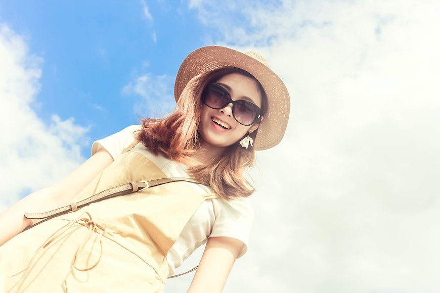 A young woman wearing a hat and sunglasses.