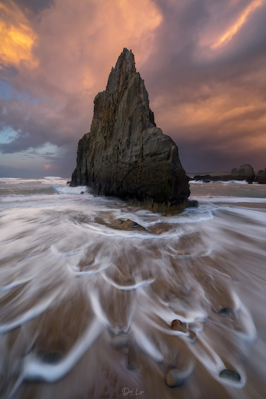 A long exposure photograph of a rock formation at sunset.
