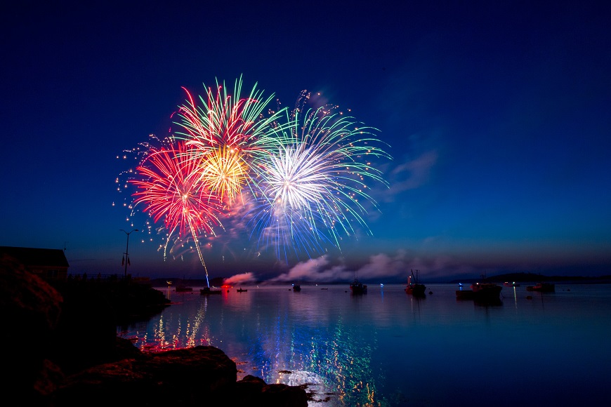 A colorful fireworks display over a body of water.