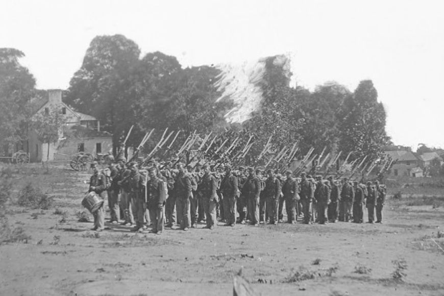 A group of men in uniform standing in a field.