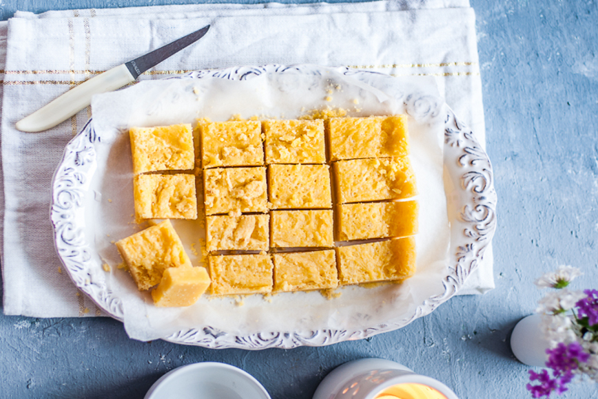 A plate with squares of yellow fudge on it.