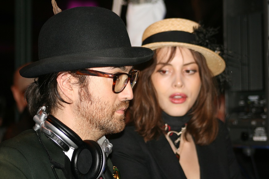A woman wearing a hat and headphones next to a man.