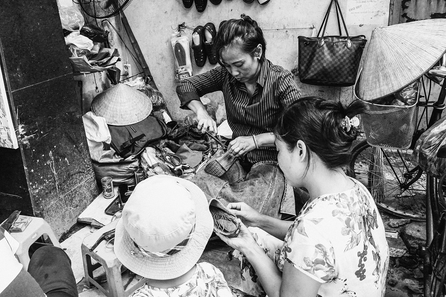 Black and white photo of women working in a shoe shop.