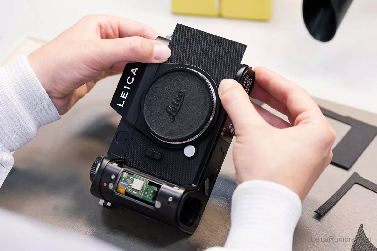 A person is working on a camera with a black cover.