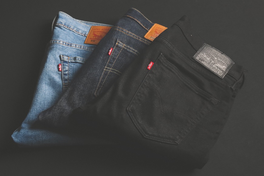Three pairs of levi's jeans on a black background.