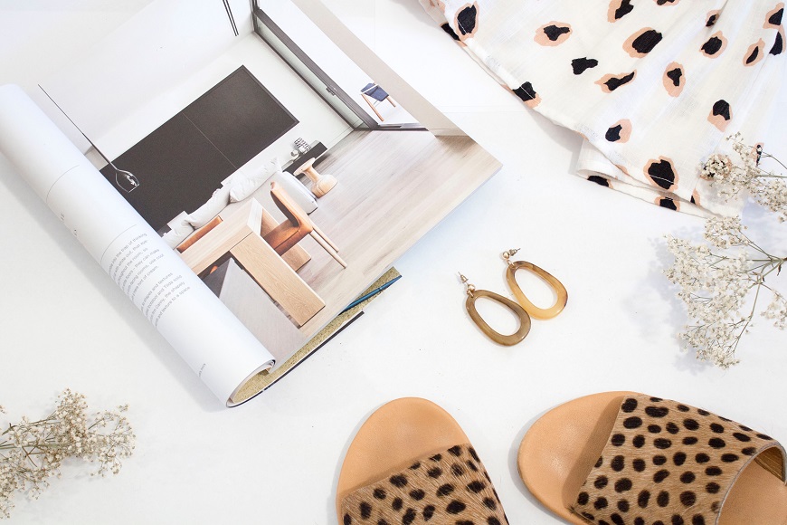 Leopard print sandals and a magazine on a table.