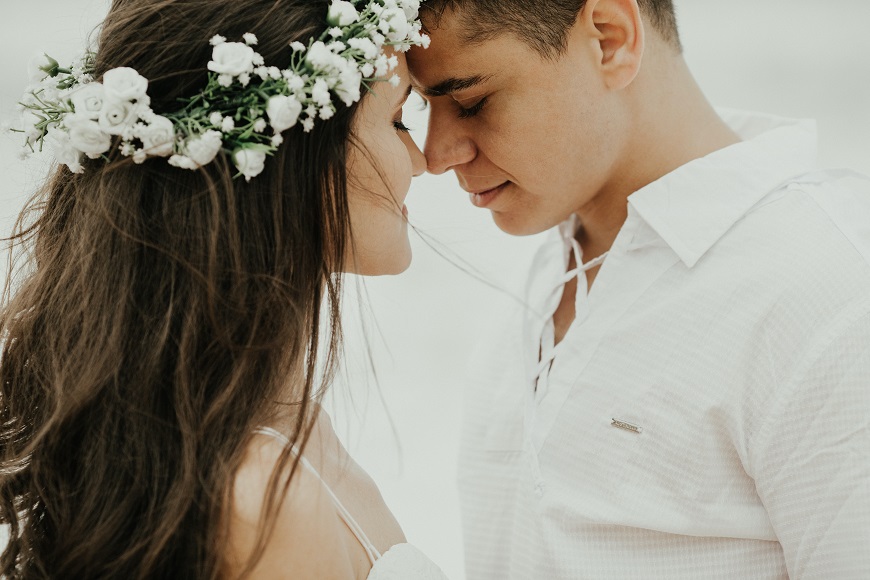 A bride and groom wearing a flower crown.