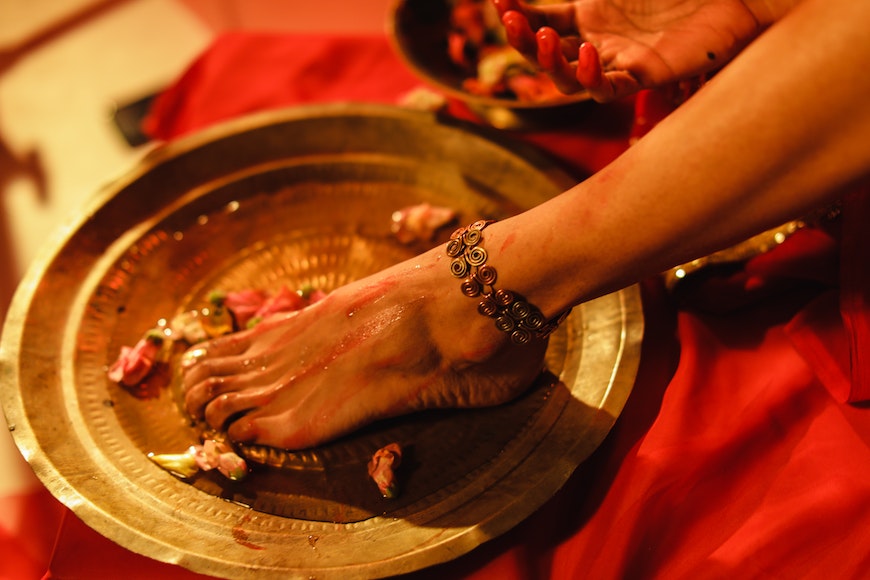 A woman's foot is placed on a plate of flowers.