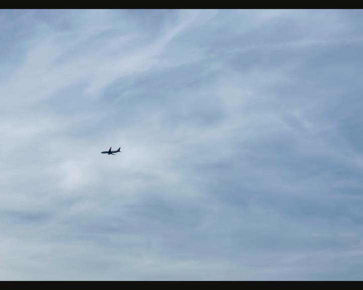 An airplane flying through a cloudy sky.