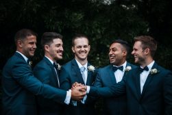 A group of groomsmen with their hands in the air.