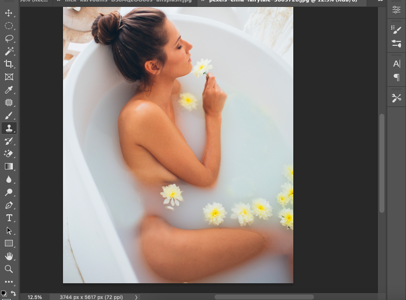 A photo of a woman laying in a bathtub with flowers.