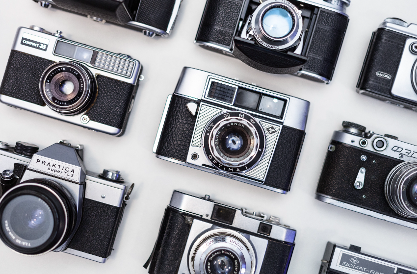 A group of vintage cameras on a white background. Digital single lens reflex