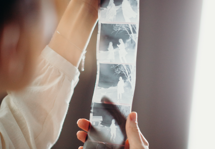 A woman is holding up digital images