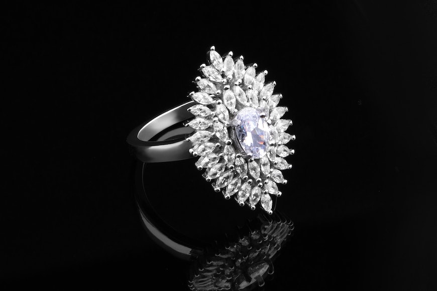 A white gold ring with a diamond in the center.