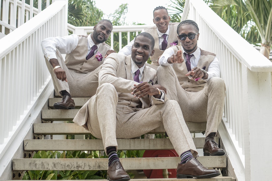 A group of groomsmen posing on a set of stairs.