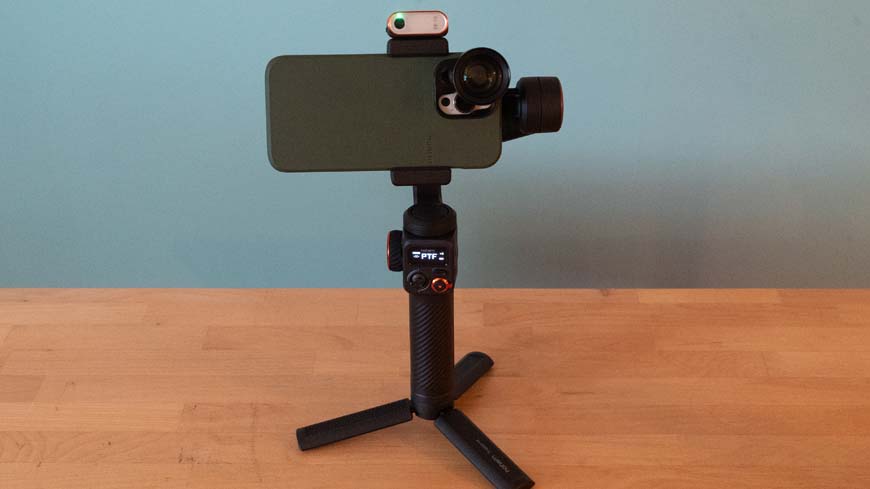 A gimbal tripod with a phone on top of it.