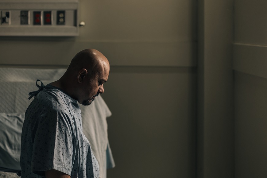 A man standing in a hospital bed.
