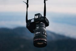 A canon dslr camera hanging from the top of a mountain.