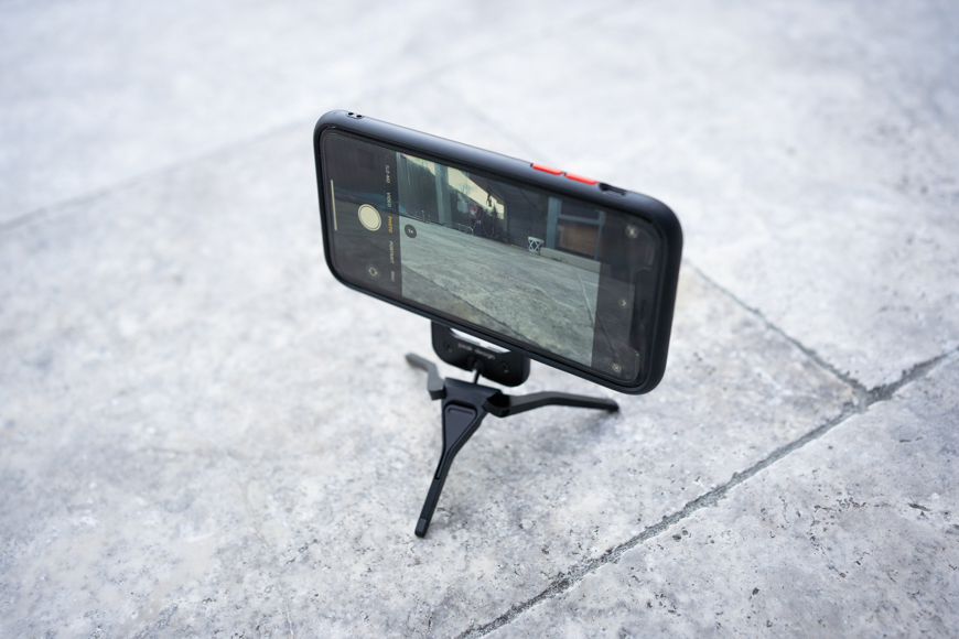A cell phone on a tripod with a camera on it.
