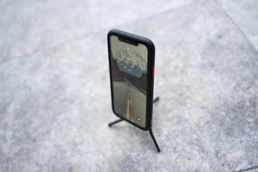 A phone on a stand on a concrete floor.