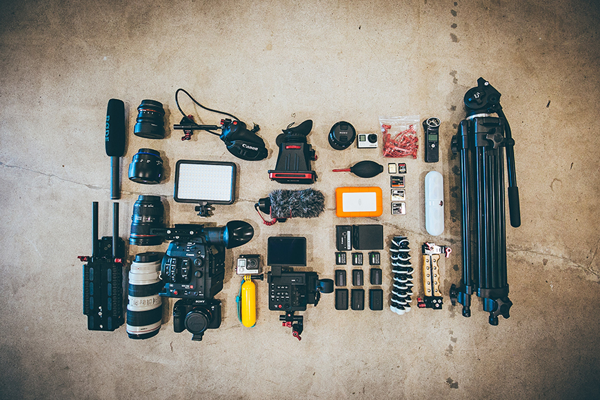 A collection of camera equipment laid out on a concrete floor.