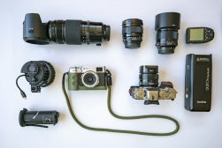A group of cameras and other equipment laid out on a white surface.