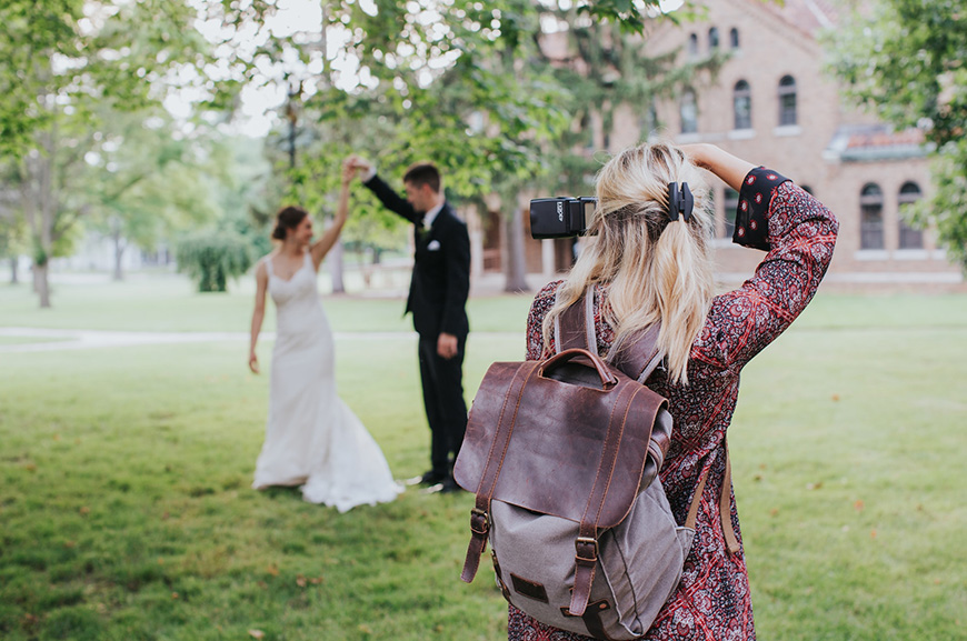 A bride and groom taking a picture with a camera.