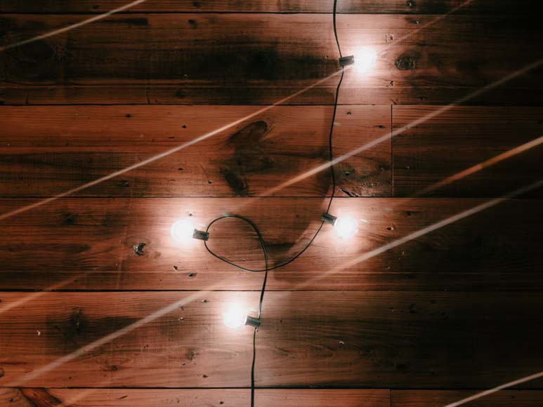 A string of lights on a wooden wall.
