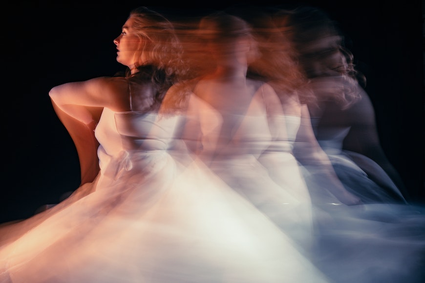 A blurry image of a woman in a white dress.