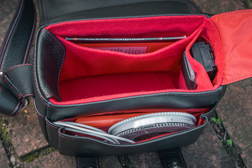 A camera bag with a red and black compartment.