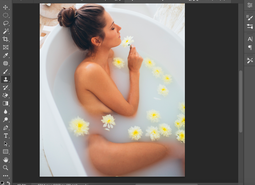 A woman is taking a bath in a bathtub with flowers.