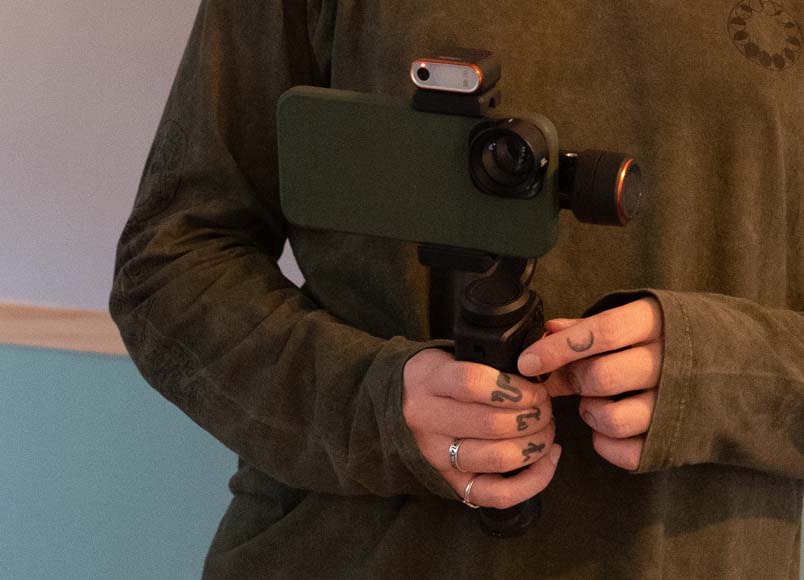 A person holding a phone with a gimbal attached to it.