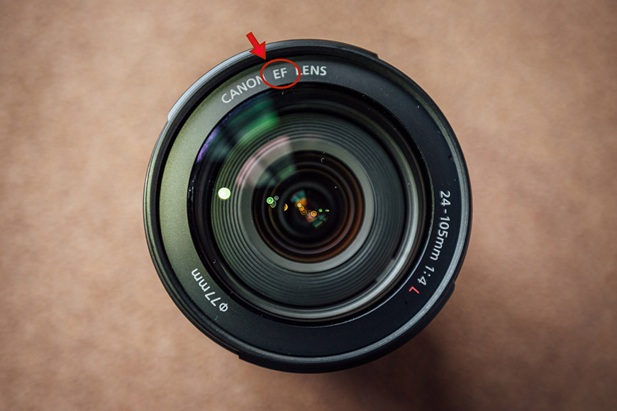 A close up of a camera lens with a red arrow pointing to it.