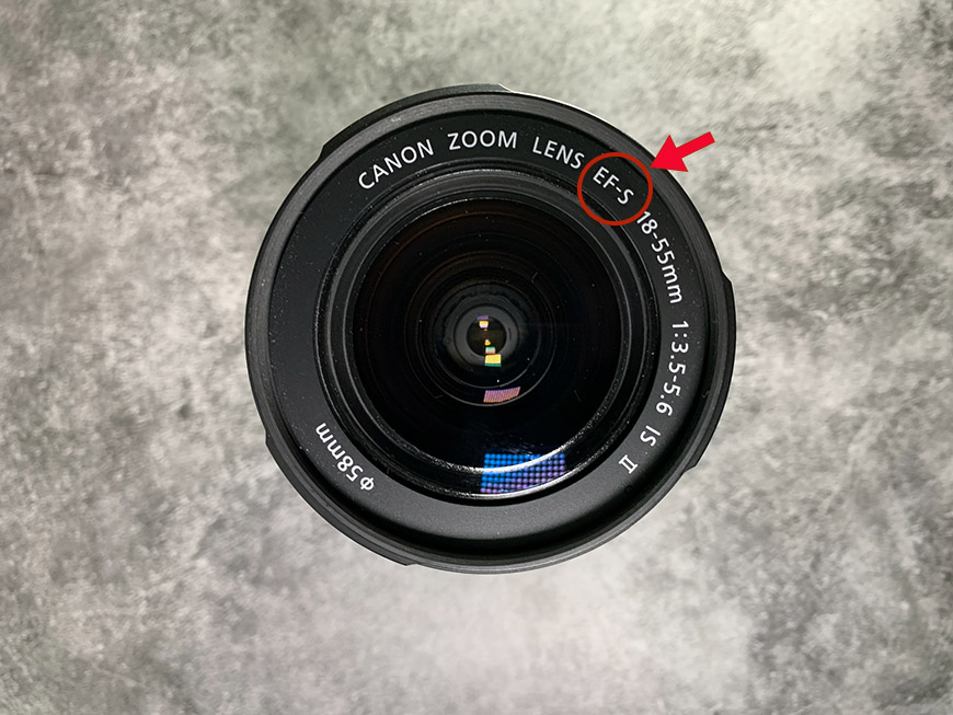 A close up of a lens with a red arrow pointing to it.