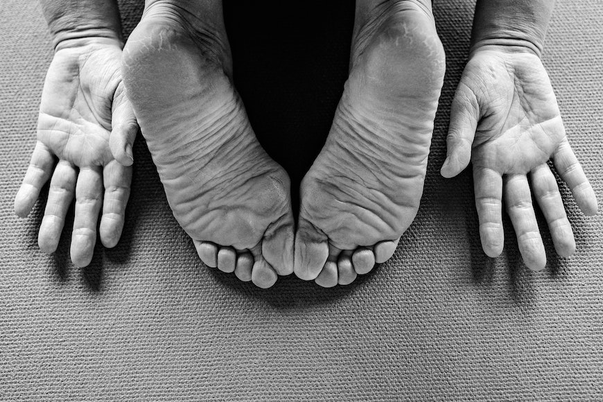 A black and white photo of a person's feet on a mat.