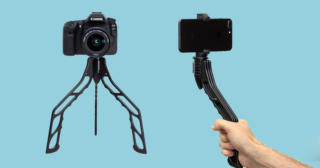 A person holding a phone and a tripod.