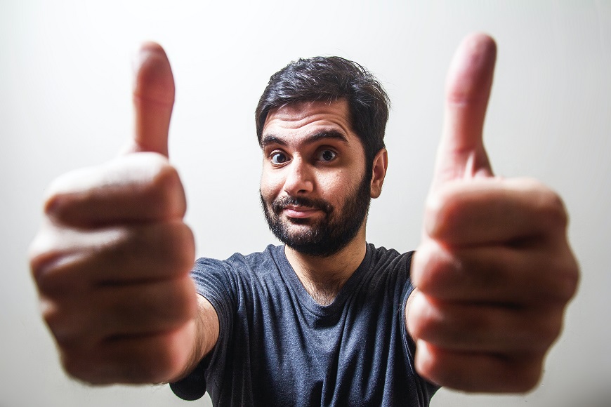 A man showing his thumbs up on a white background.