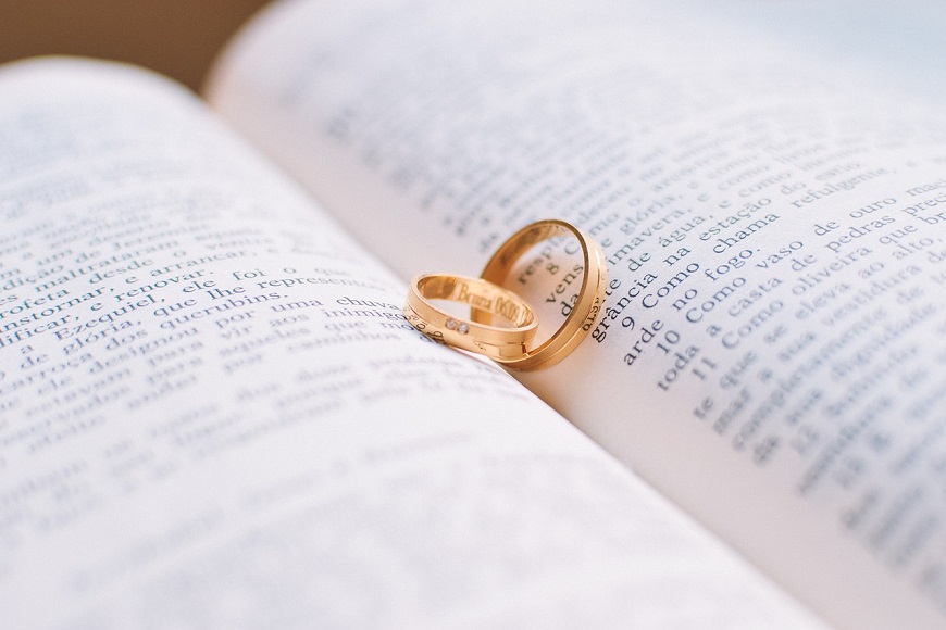 Two wedding rings on top of an open book.
