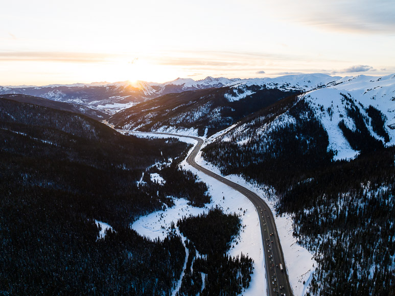 An aerial view of a snowy road in the mountains.