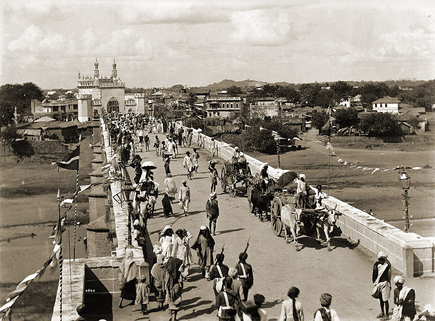 A group of people walking across a bridge.