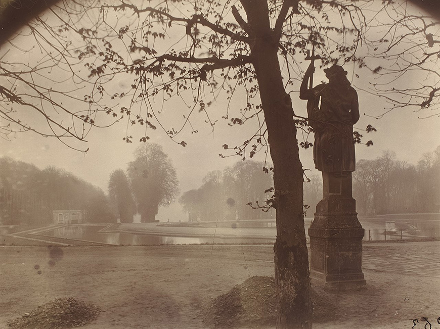 An old photograph of a statue in a park.
