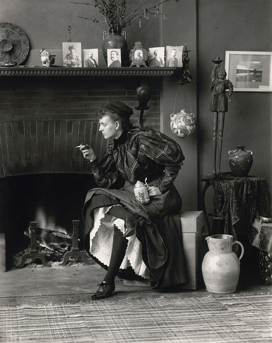 A woman sitting in front of a fireplace.