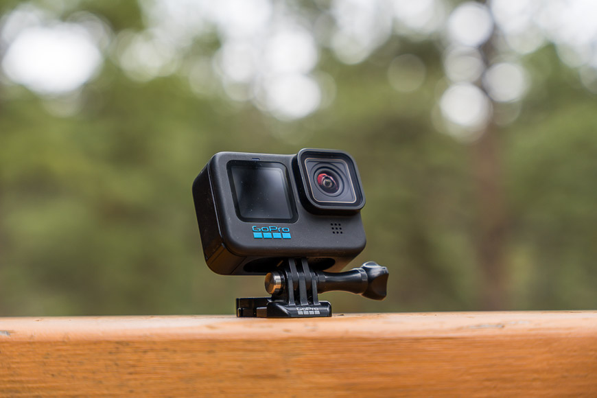 A gopro hero 4 black sits on top of a wooden bench.
