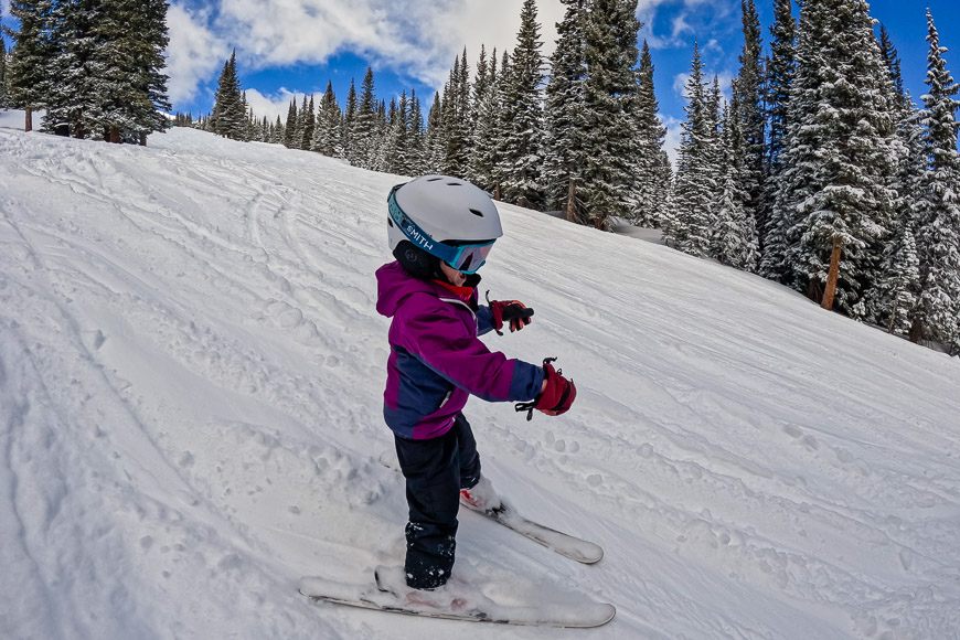 A child is skiing down a snowy slope.