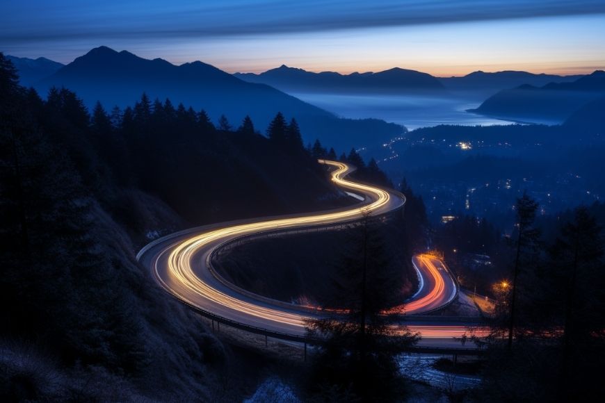 A winding road in the mountains at dusk.