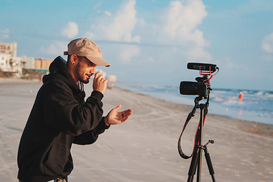 A man with a camera on the beach.