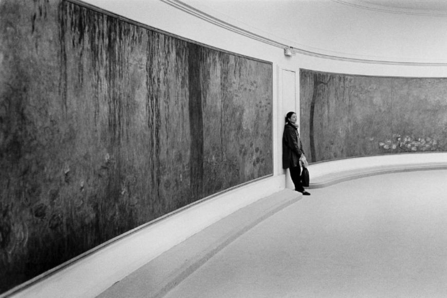 A man standing in front of a large painting.