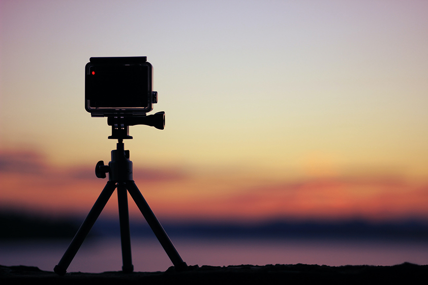 A tripod with a camera on it at sunset.