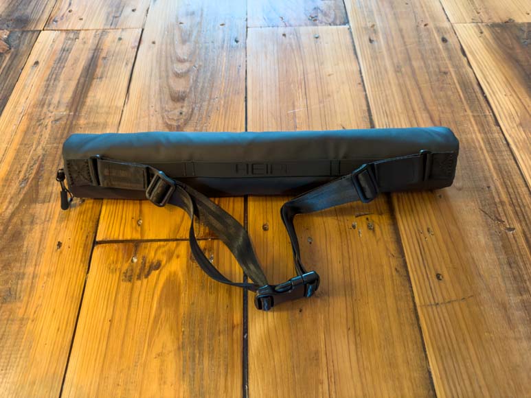A black bag sitting on a wooden floor.